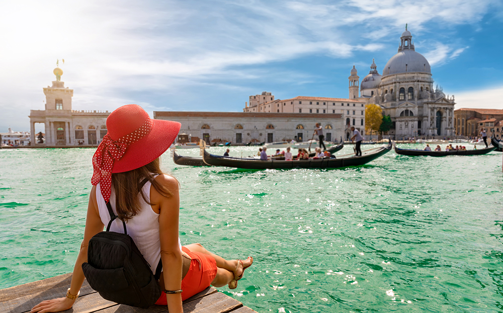 Female tourist looking the Basilica di Santa Maria della Salute and Canale Grande in Venice, Italy